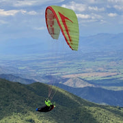 Grüner RC Gleitschirm Stable 2.1 Race Rast fliegt am Liegegurtzeug Rocket durch eine Berglandschaft