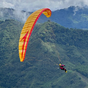 RC Paraglider Stable 2.1 Race Rast mit Pilotin Anna Free fliegt vor einer Bergwald Kulisse