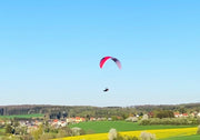RC Gleitschirm in rot fliegt über gelbes Rapsfeld