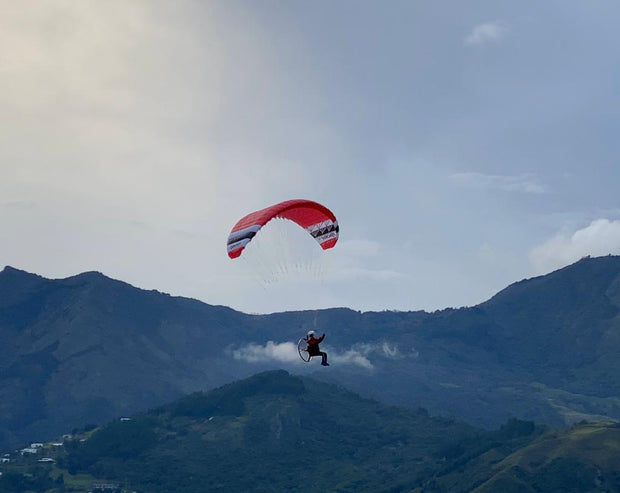RC Gleitschirm fliegt mit Pilot Noah vor  Wolke und Berglandschaft
